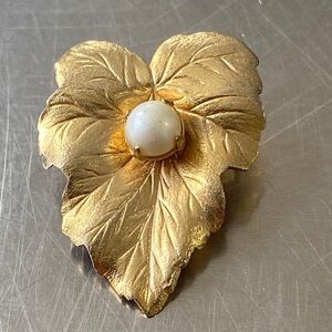 vintage Sarah Coventry gold-tone leaf brooch with a central faux pearl.
